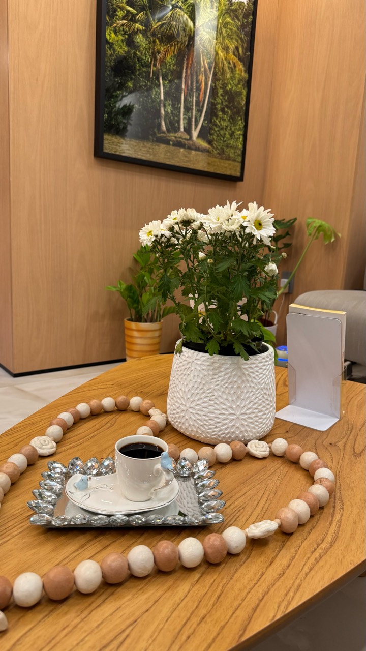 Detalhe da mesa com flores brancas e uma xícara de café